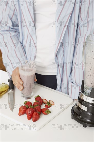 Asian man making fruit smoothie