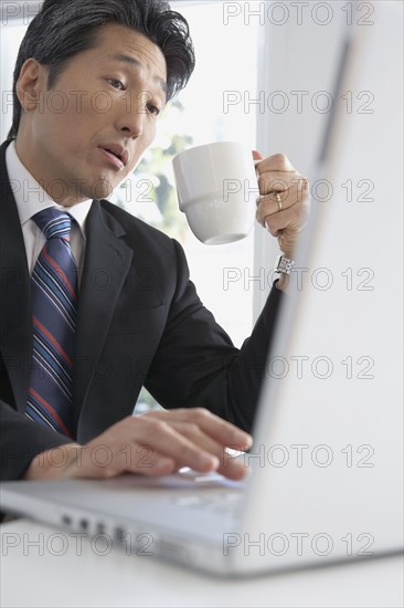 Asian businessman typing on laptop