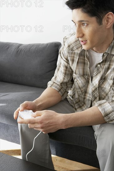 Asian man playing video games