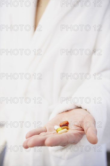 Asian man holding pills in hand