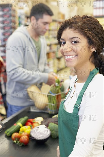 Mixed Race cashier at grocery store