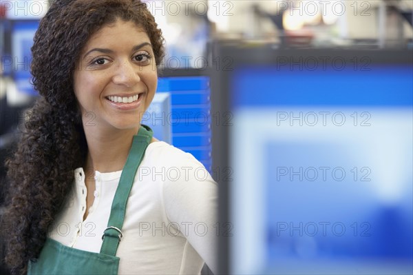 Mixed Race cashier wearing apron