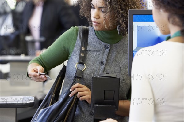 African woman looking at credit card