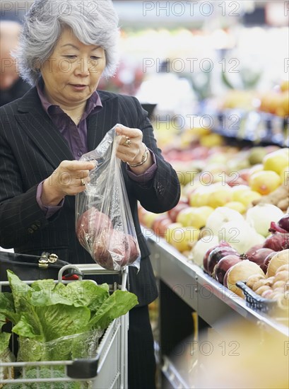 Senior Asian woman shopping for produce