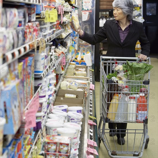 Senior Asian woman shopping in grocery store