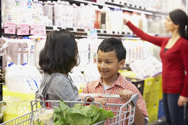 Indian brother pushing sister in shopping cart