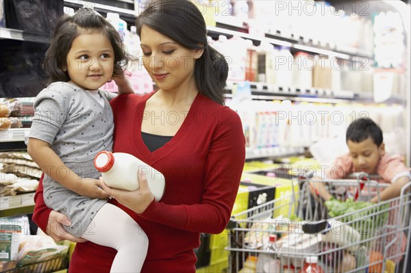 Indian mother grocery shopping with children