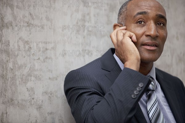 Mixed race businessman talking on cell phone