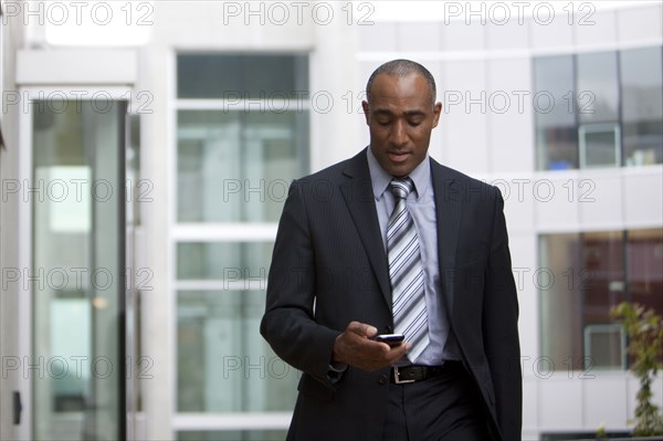 Mixed race man looking at cell phone