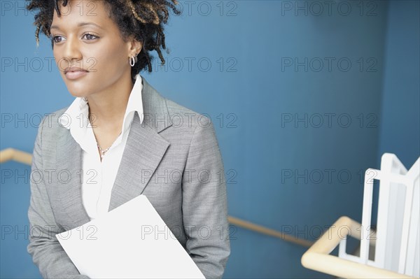 Mixed race businesswoman in stairwell