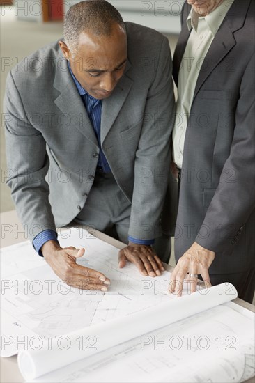 Businessmen looking at blueprints