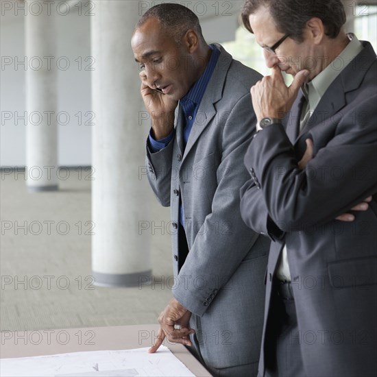 Businessmen looking at blueprints