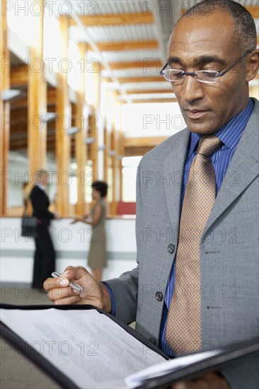 Mixed businessman looking at paperwork