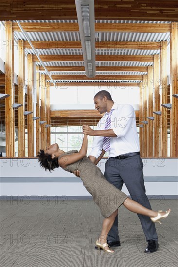 Couple dancing in empty office space