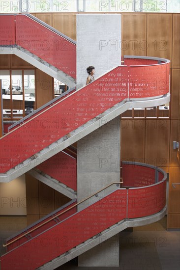 Mixed race businesswoman climbing stairs in office