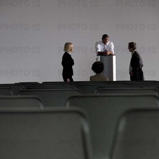 Business people talking in empty auditorium