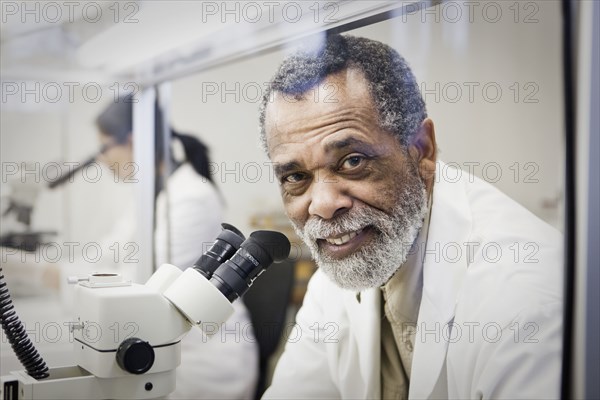 African American scientist using microscope in laboratory