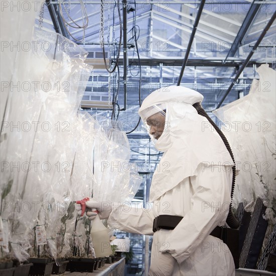 Scientist in clean suit working in greenhouse