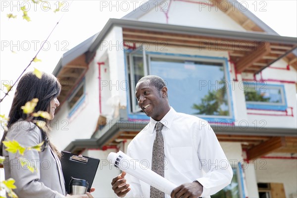 Real estate agents near house under construction