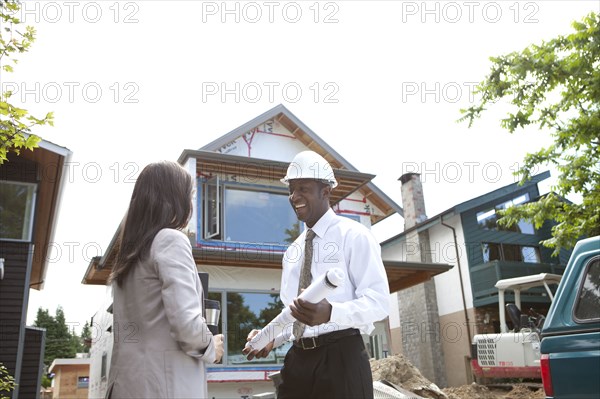 Real estate agents near house under construction