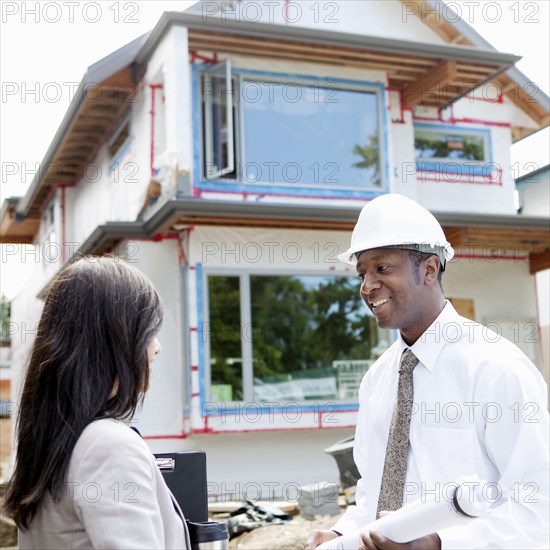 Real estate agents near house under construction
