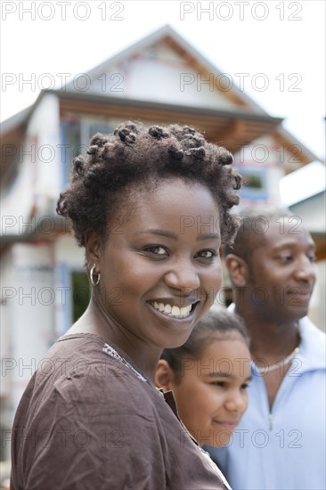 Family standing near house under construction