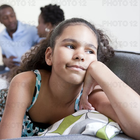 Bored girl sitting on couch with parents