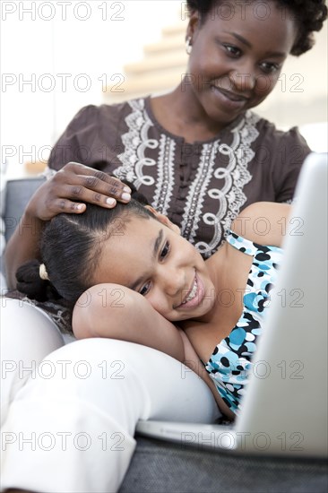 Mother and daughter using laptop together