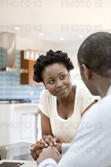 Black couple holding hands in kitchen