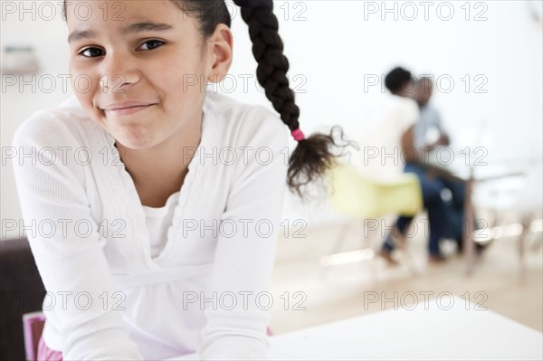 Smiling girl with parents in background