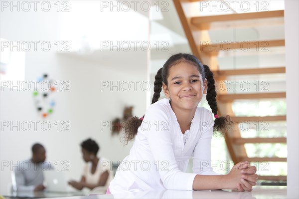 Smiling girl with parents in background