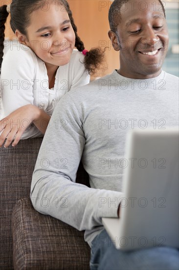 Father and daughter using laptop together