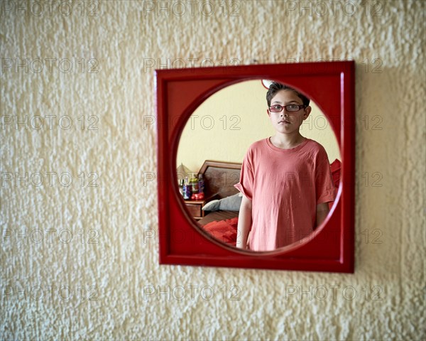 Hispanic boy admiring himself in mirror