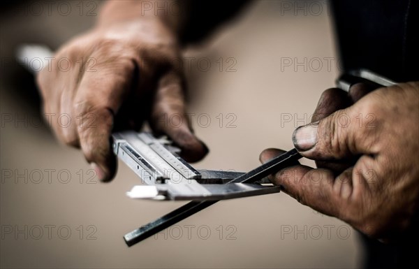 Close up of worker measuring metal