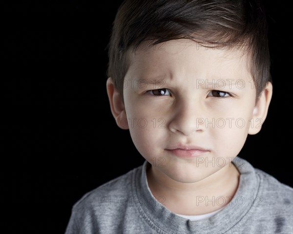 Close up of Hispanic boy frowning