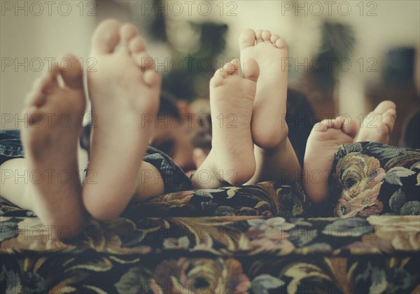 Close up of feet of children on sofa