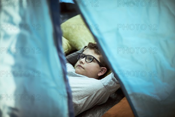Hispanic boy camping in tent