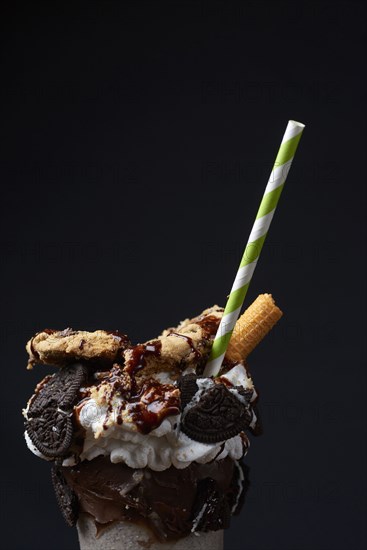 Straw in ice cream sundae with cookies