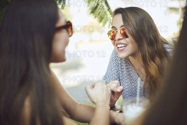 Smiling Hispanic women wearing sunglasses