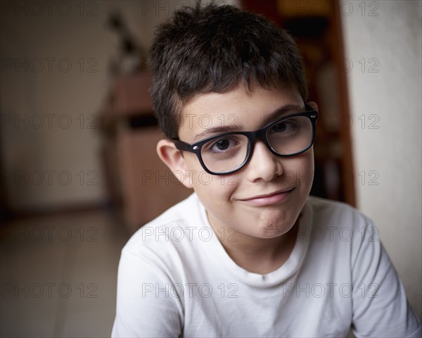 Smirking Hispanic boy wearing eyeglasses