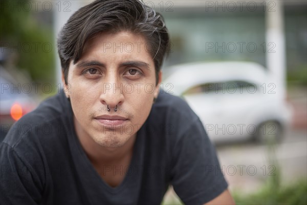 Serious Hispanic man with pierced nose