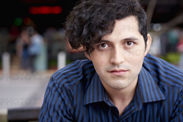 Serious Hispanic man with curly hair