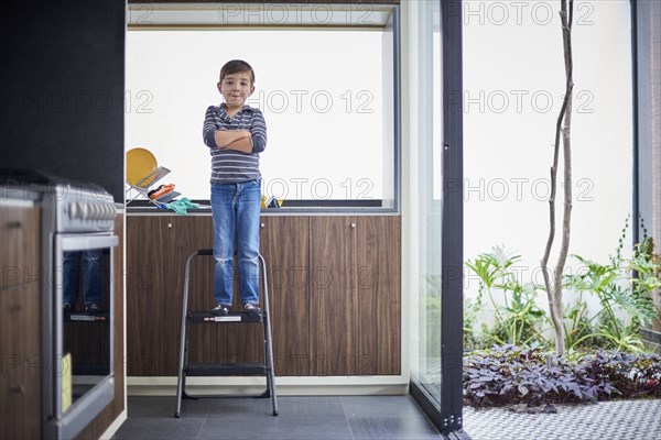 Hispanic boy standing on ladder