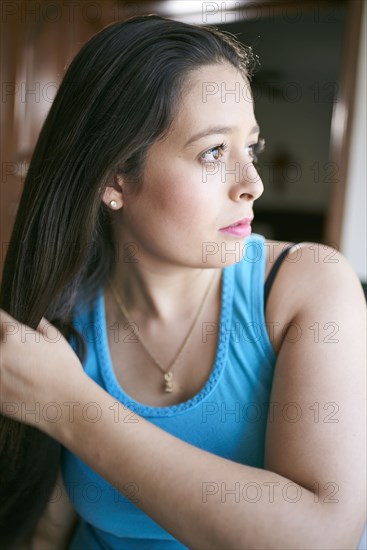 Hispanic woman brushing hair
