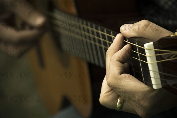 Hands on man playing guitar