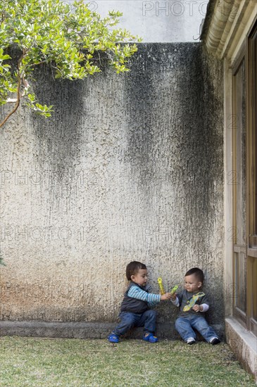 Hispanic boys playing in yard