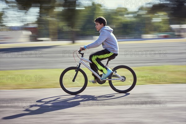 Hispanic boy riding bicycle
