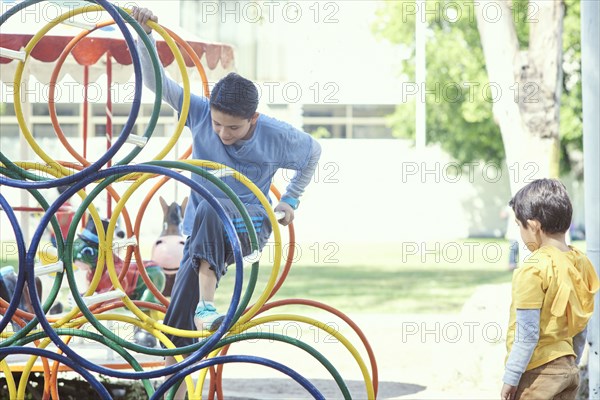 Hispanic boys climbing on structure at playground