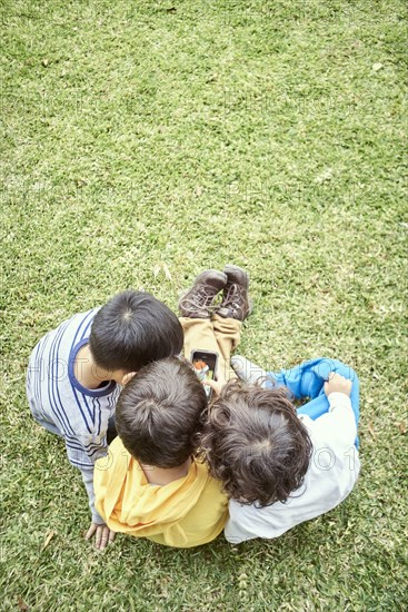 Hispanic boys playing with cell phone