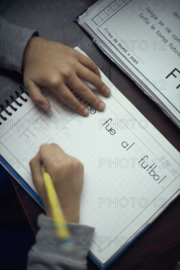 Hispanic boy practicing writing alphabet